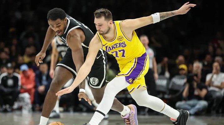 Luka Dončić dari Los Angeles Lakers berebut bola dengan Day’Ron Sharpe dari Brooklyn Nets pada kuarter pertama di Barclays Center